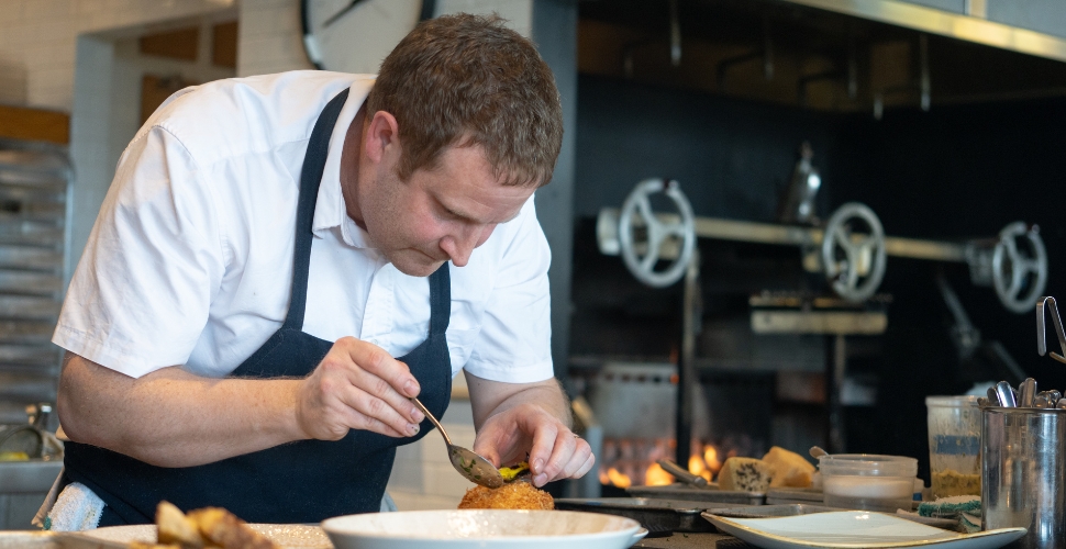 Home Block Restaurant at Cedar Creek's Executive Chef Neil Taylor personally preparing dishes in their open-concept kitchen