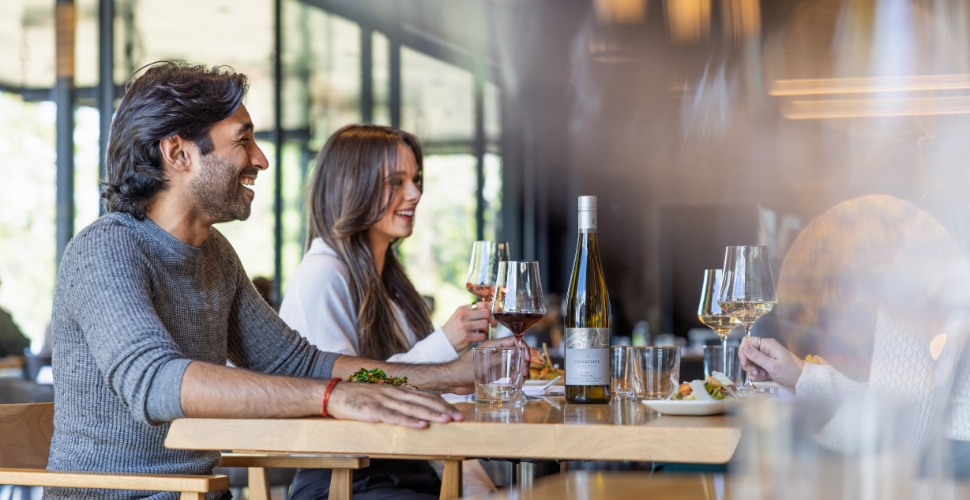 A group enjoying an intimate dining experience inside Home Block Restaurant at Cedar Creek paired with Platinum tier wines